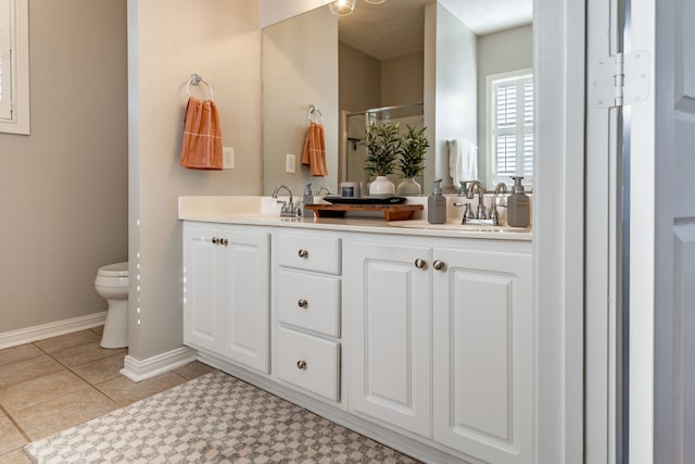 bathroom featuring a textured ceiling, vanity, a shower with door, tile patterned flooring, and toilet