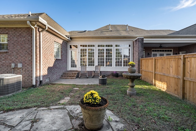 rear view of house featuring a lawn and central AC