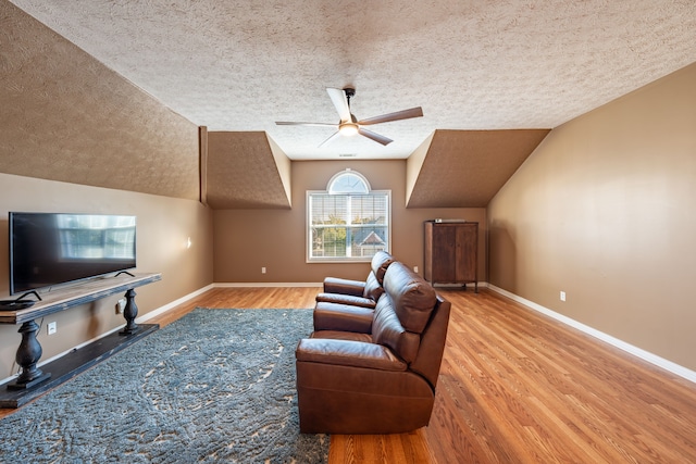 living room featuring a textured ceiling, ceiling fan, vaulted ceiling, and hardwood / wood-style flooring