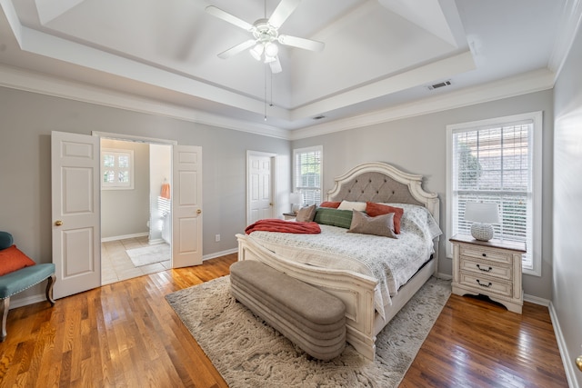 bedroom with a tray ceiling, light hardwood / wood-style flooring, ceiling fan, and crown molding