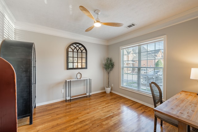 home office with ceiling fan, ornamental molding, a textured ceiling, and light wood-type flooring