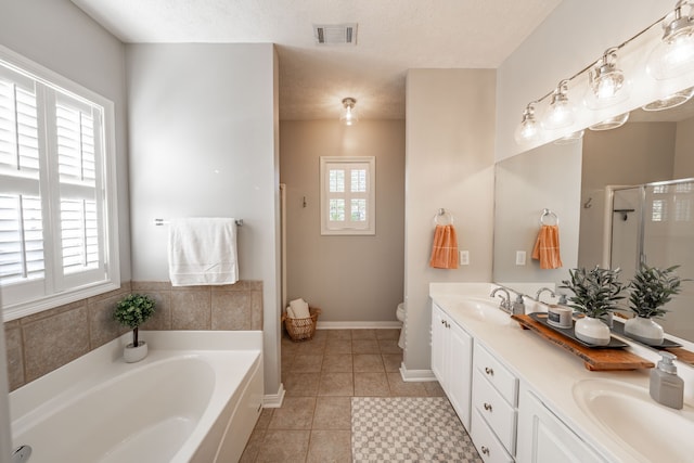 bathroom with vanity, a textured ceiling, tile patterned floors, and plus walk in shower