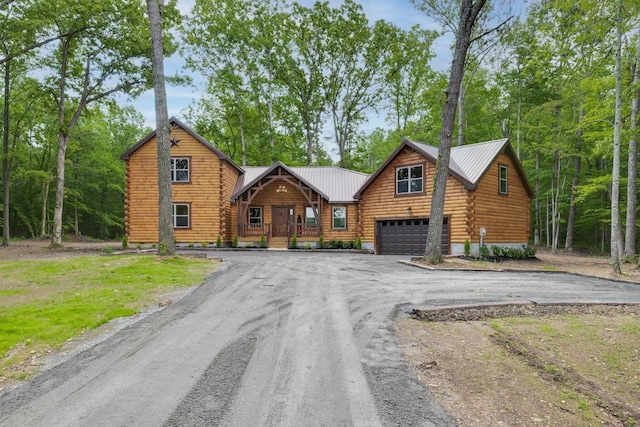 cabin featuring a porch and a garage