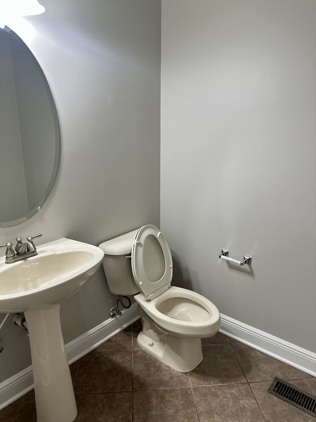 bathroom featuring tile patterned flooring, toilet, and sink