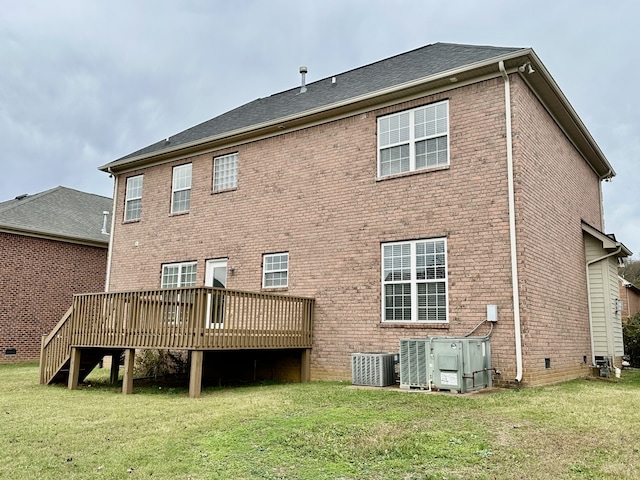 rear view of property featuring a yard, central AC unit, and a wooden deck