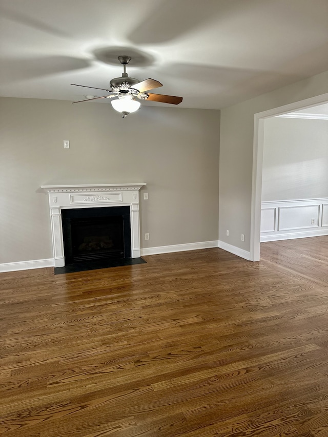 unfurnished living room featuring ceiling fan and dark wood-type flooring