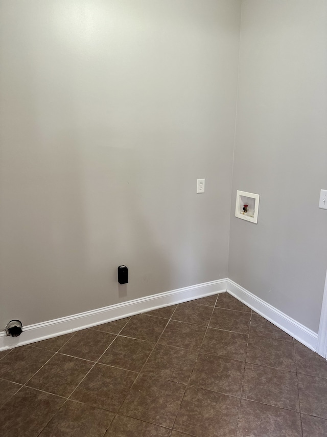 washroom with hookup for a washing machine and dark tile patterned floors