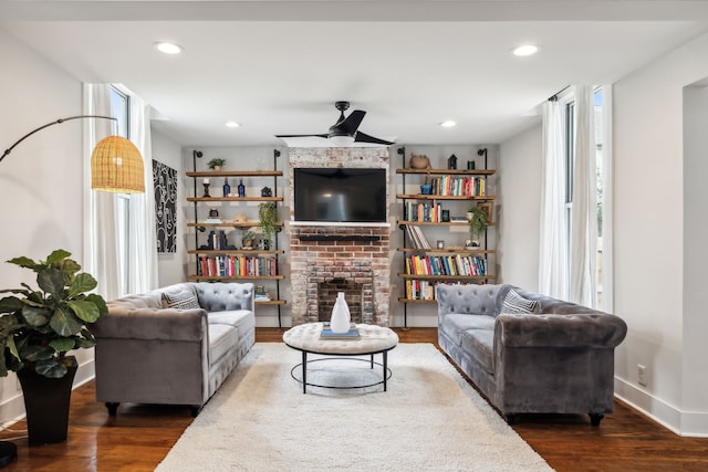 living room featuring a wealth of natural light, dark wood-type flooring, and ceiling fan