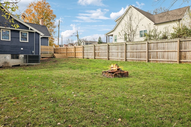 view of yard featuring a fire pit and central AC unit