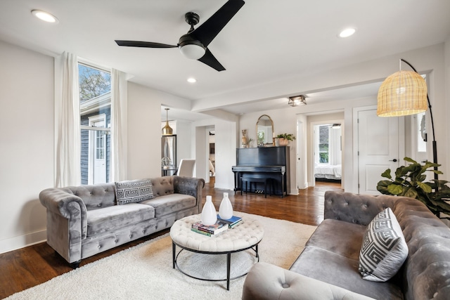 living room with dark hardwood / wood-style flooring and ceiling fan