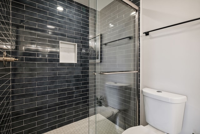 bathroom featuring toilet and a shower with shower door