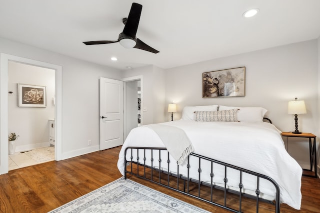 bedroom with hardwood / wood-style floors, ceiling fan, and ensuite bath