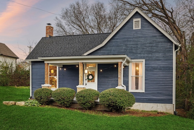 view of front of property with a porch and a yard