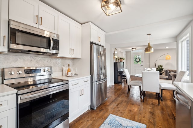 kitchen featuring white cabinetry, plenty of natural light, dark hardwood / wood-style floors, and appliances with stainless steel finishes