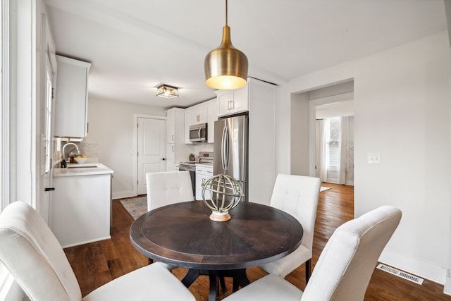 dining space with dark hardwood / wood-style floors and sink