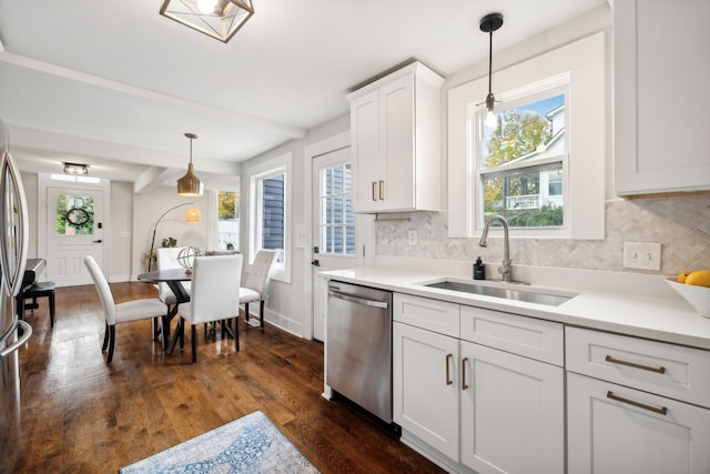 kitchen with pendant lighting, dark wood-type flooring, sink, stainless steel dishwasher, and white cabinetry