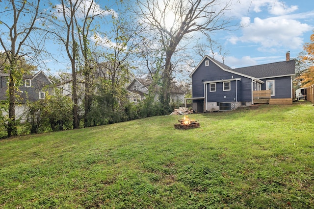 view of yard featuring cooling unit, a fire pit, and a deck