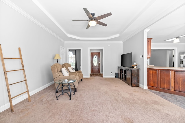 sitting room featuring a raised ceiling, light carpet, ceiling fan, and ornamental molding