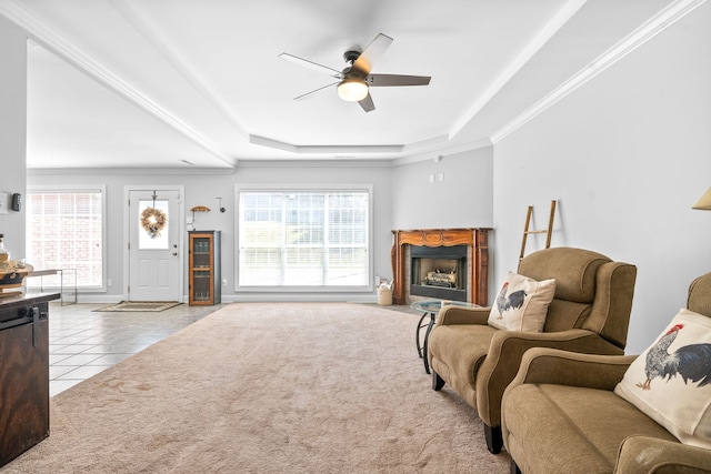 tiled living room featuring ceiling fan, crown molding, and a tray ceiling