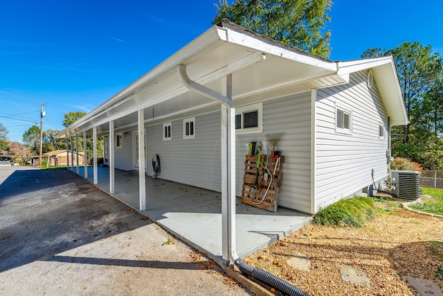 view of property exterior featuring central AC unit and a carport