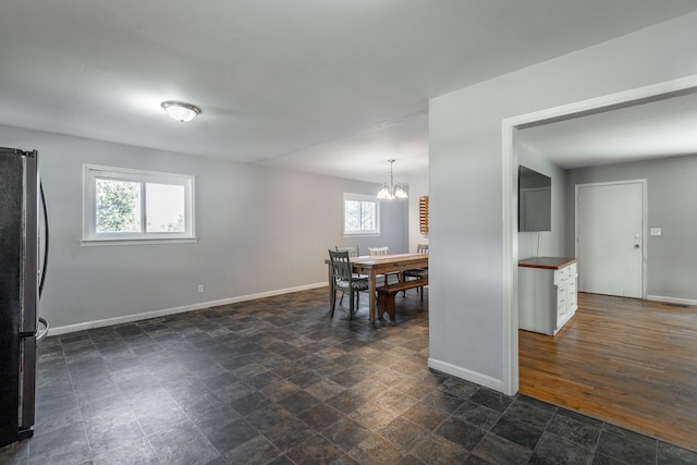 dining space featuring a chandelier, a healthy amount of sunlight, and dark hardwood / wood-style floors