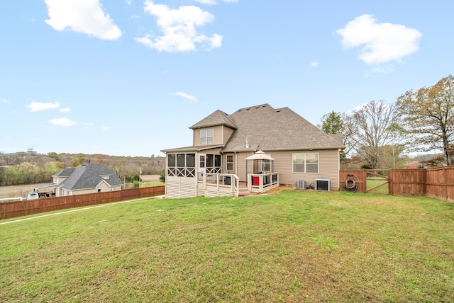 back of house featuring a sunroom, cooling unit, and a yard