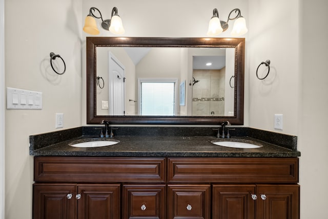 bathroom featuring a tile shower and vanity