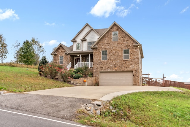 view of front of property featuring a porch, a front yard, and a garage