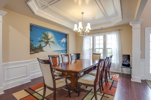 dining room with ornate columns, a raised ceiling, dark hardwood / wood-style floors, crown molding, and a chandelier