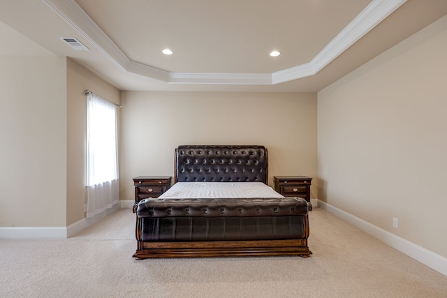 bedroom with light colored carpet, a raised ceiling, and ornamental molding