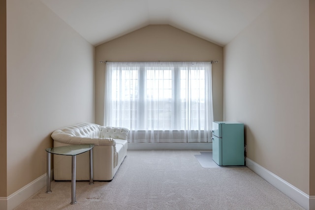 sitting room featuring light colored carpet and lofted ceiling