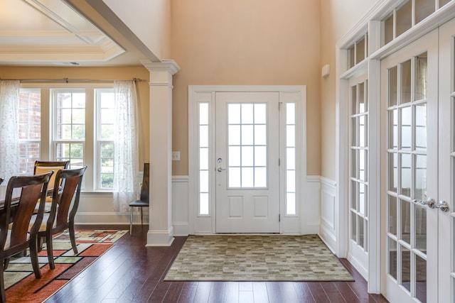 entryway featuring ornate columns, dark hardwood / wood-style flooring, a healthy amount of sunlight, and ornamental molding