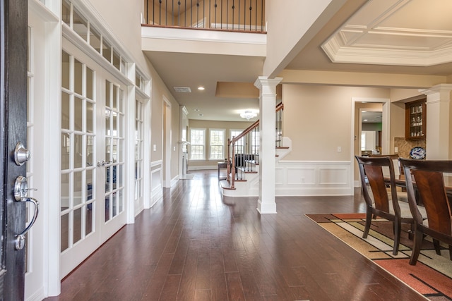 entryway featuring french doors, ornate columns, dark wood-type flooring, and crown molding