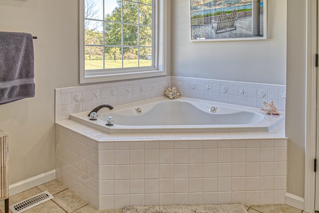 bathroom featuring tiled tub and tile patterned flooring