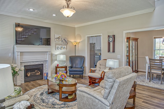 living room featuring crown molding, a textured ceiling, and hardwood / wood-style flooring