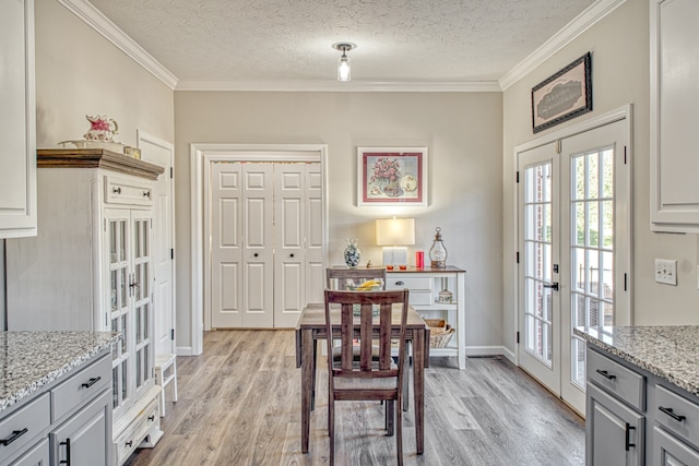 dining space featuring crown molding, french doors, and light hardwood / wood-style flooring