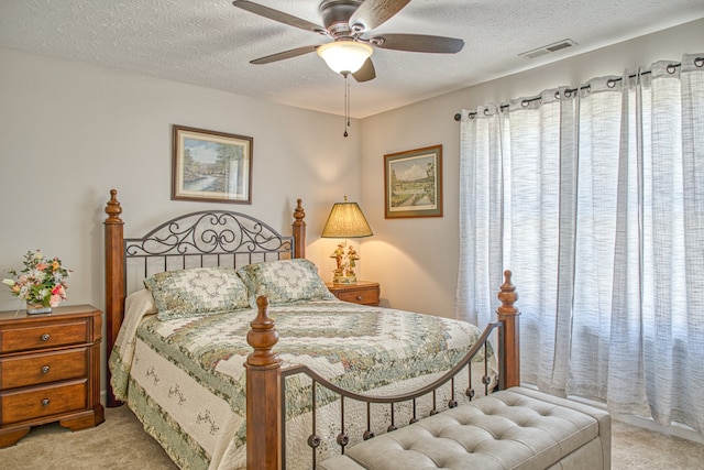 carpeted bedroom featuring a textured ceiling and ceiling fan