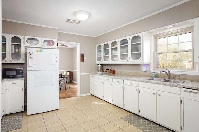 kitchen featuring white cabinetry, sink, light tile patterned flooring, and white appliances