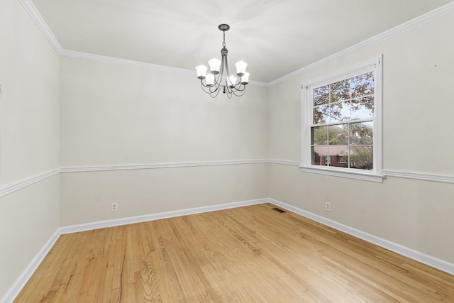 empty room featuring wood-type flooring, crown molding, and a chandelier