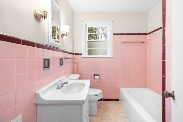 bathroom featuring a bath, vanity, tile patterned floors, and tile walls