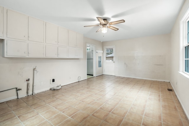 tiled spare room with ceiling fan