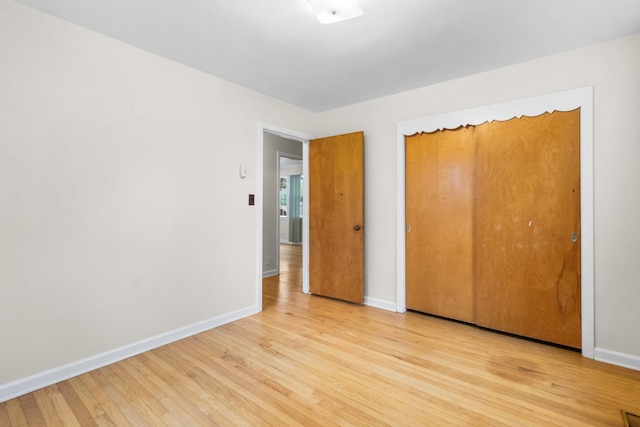 unfurnished bedroom featuring a closet and light hardwood / wood-style floors