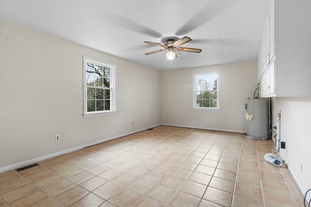 tiled spare room with ceiling fan and water heater