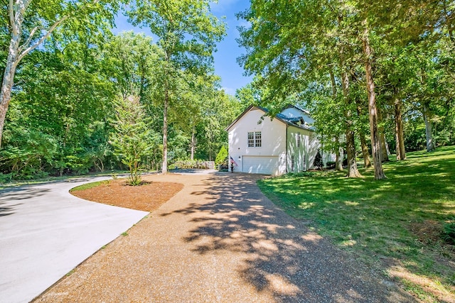 view of side of home with a lawn and a garage