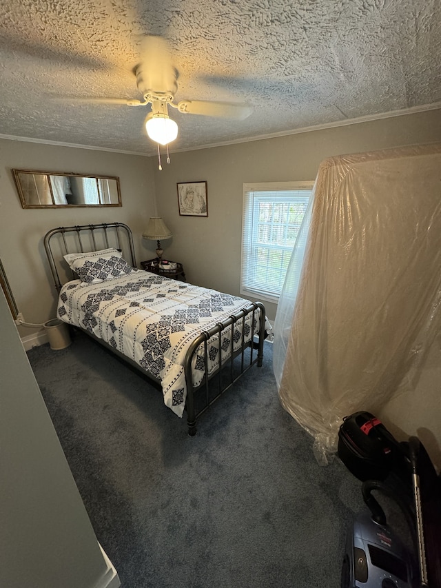 bedroom featuring dark colored carpet, ceiling fan, ornamental molding, and a textured ceiling