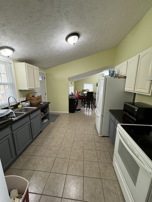 kitchen with gray cabinetry, sink, white electric range, light tile patterned flooring, and white cabinets