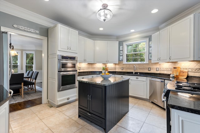 kitchen featuring plenty of natural light, a kitchen island, crown molding, and stainless steel appliances