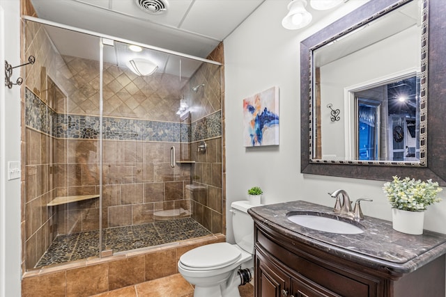 bathroom featuring tile patterned flooring, toilet, an enclosed shower, and vanity