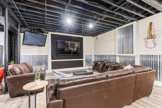 living room with hardwood / wood-style floors and wood walls