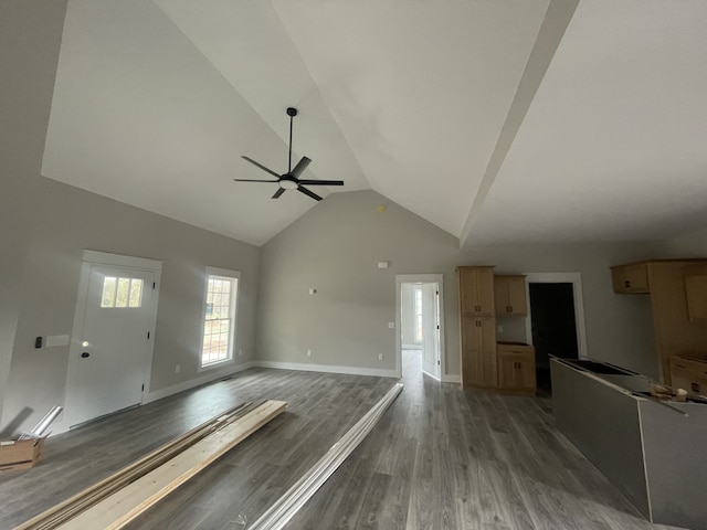 unfurnished living room featuring dark hardwood / wood-style floors, ceiling fan, and high vaulted ceiling